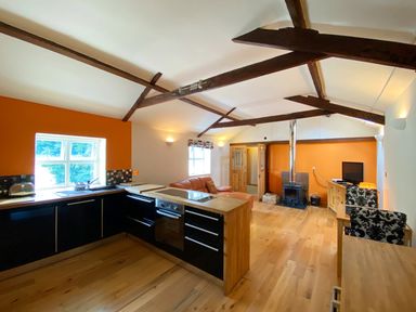 A kitchen with a sofa and television at Upper Stable - The Stables Apartments at Meadfoot Bay, Torquay