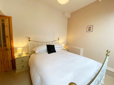 A bedroom with a bed and bedside table at Upper Stable - The Stables Apartments at Meadfoot Bay, Torquay