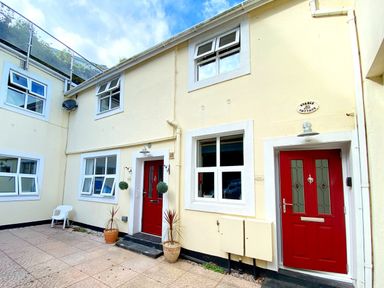 An outdoor entrance with red doors and windows at Upper Stable - The Stables Apartments at Meadfoot Bay, Torquay