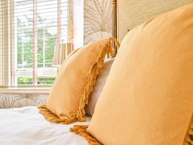 A bedroom with decorative pillows and a lamp at Muntham - Studio Apartment 7 in Torquay