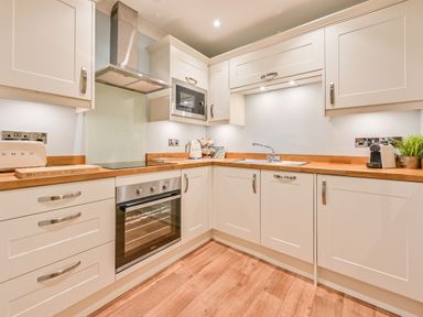 A kitchen with cabinets, oven, sink, and microwave at Muntham - Studio Apartment 7, Torquay