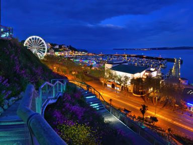 An outdoor view of a marina, street, and ferris wheel at Muntham - Studio Apartment 7 in Torquay