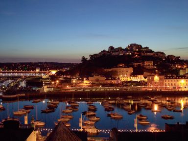 A view of boats and buildings at night at Muntham - Studio Apartment 7 in Torquay