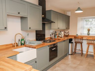 A kitchen with cabinets and a sink at Starlight Cottage 