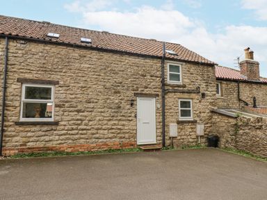 A stone exterior of a cottage with windows and a door at Starlight Cottage 