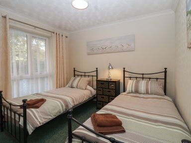 A bedroom with two beds and a drawer unit at Willow Lodge Rosecraddoc Lodge near Liskeard