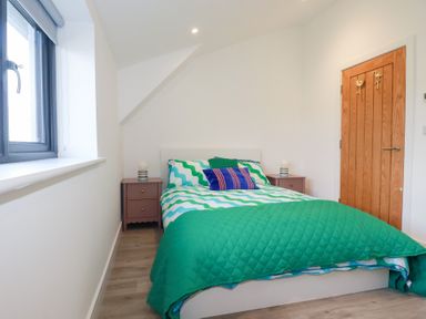A bedroom with a bed and nightstand at Barn 5