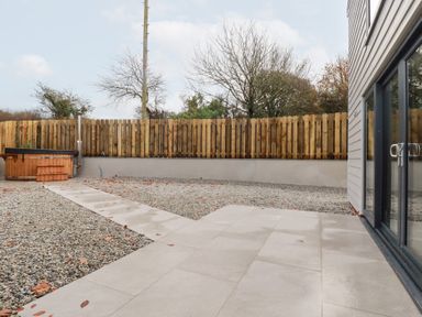 A garden with a hot tub and gravel pathway at Barn 5 