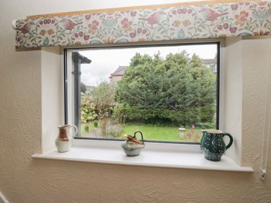 A window with decorative jugs on sills at Apple Byrd in Kendal