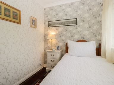 A bedroom with a bed, nightstand, and lamp at Apple Byrd in Kendal