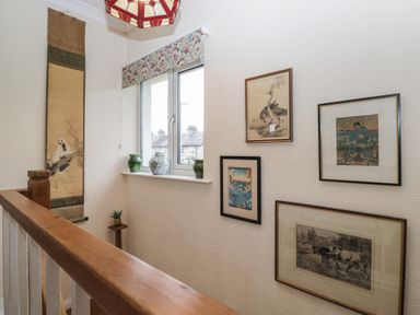 A hallway with artworks on the wall at Apple Byrd in Kendal