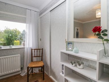 A room with a chair, shelf, and mirror at Apple Byrd in Kendal