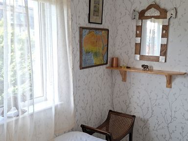 A bedroom with a map and a mirror on the wall at Apple Byrd in Kendal