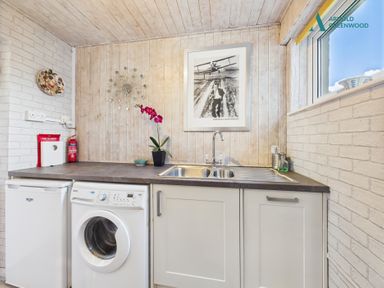 A kitchen with a washing machine and a sink at Apple Byrd in Kendal