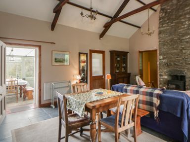 A dining room with a table and chairs at Tyn Y Fron in Brynherbert near Llanrhystud