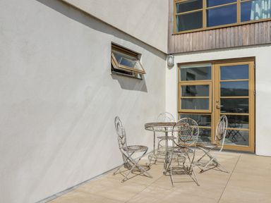 An outdoor seating area with a table and chairs at Teach Tra East in Perranporth