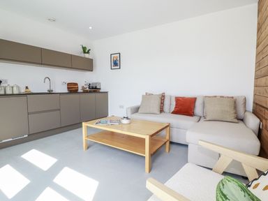A living room with a sofa and coffee table at Teach Tra East Perranporth