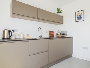 A kitchen with cabinets and appliances at Teach Tra East Perranporth