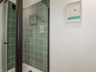 A shower enclosure with tiles in a bathroom at Teach Tra East Perranporth