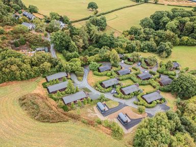 An aerial view of a cluster of cabins in a rural setting at Oak View in Rhayader