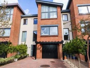 A townhouse with a garage and plants at Harbour Heights in Weymouth