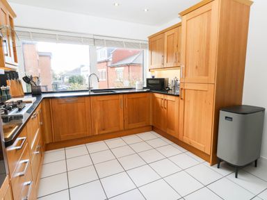 A kitchen with wooden cabinets and a sink at Harbour Heights in Weymouth