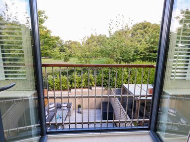 A balcony with a view overlooking greenery and outdoor seating at Harbour Heights in Weymouth