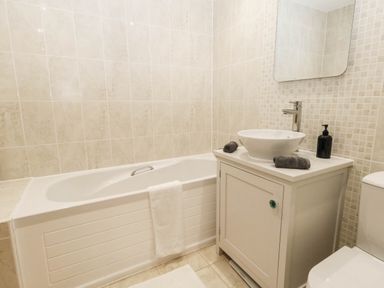 A bathroom with a bathtub, sink, and toilet at Harbour Heights in Weymouth