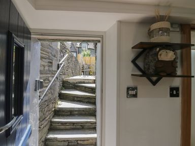 An entryway with steps and a shelf with a stuffed toy at Park View Studio Ambleside