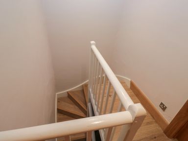 A staircase view with a handrail and wooden floor at Park View in Ambleside