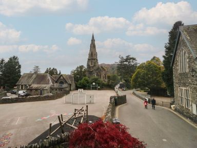 A view of a school building with a church in the background at Park View in Ambleside