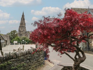 A church and a red tree in a playground area at Park View in Ambleside