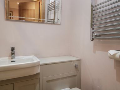 A bathroom with a sink, mirror, and towel rail at Park View in Ambleside