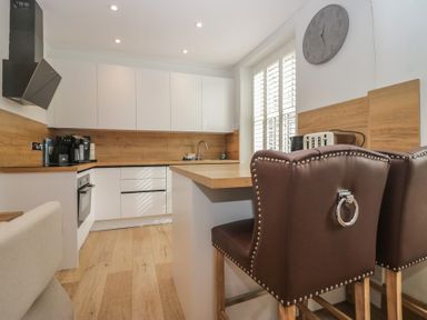 A kitchen with modern appliances and bar stools at Park View in Ambleside