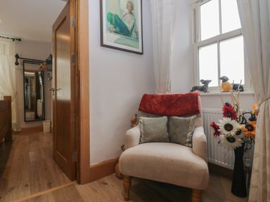A hallway with a chair and window at Park View in Ambleside