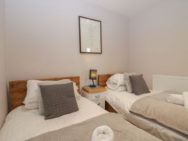 A bedroom with two beds and a bedside table at Park View in Ambleside