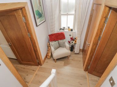 A hallway with a chair and decorative items at Park View in Ambleside