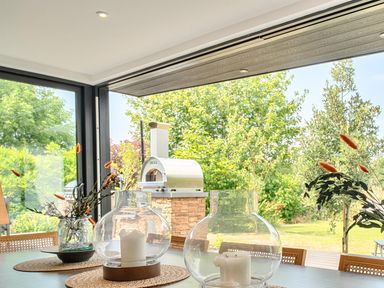 A dining room with vases and a view of an outdoor oven at Manor Farm House in Merton near Bicester