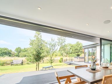 A dining room with a table and chairs overlooking a garden at Manor Farm House in Merton near Bicester