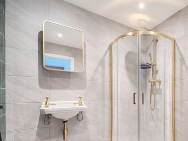 A bathroom with a shower, mirror, and sink at Manor Farm House in Merton near Bicester
