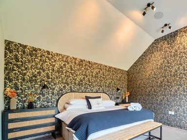 A bedroom with a bed and decorative wall at Manor Farm House in Merton near Bicester