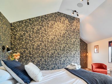 A bedroom with a bed and armchair at Manor Farm House in Merton near Bicester
