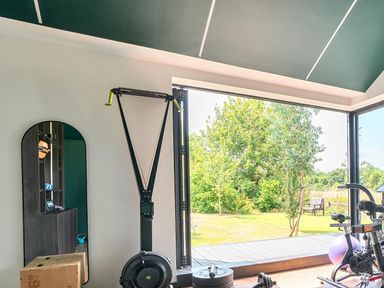 A gym with exercise equipment and an outdoor view at Manor Farm House in Merton near Bicester