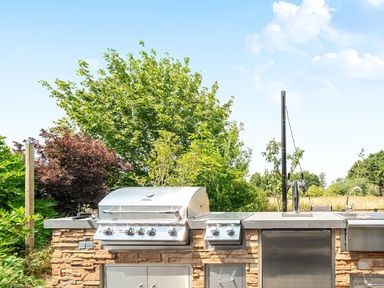 An outdoor kitchen with a grill and sink at Manor Farm House in Merton near Bicester