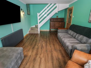 A living room with a sofa and television at 61 Lloyd Street West Llandudno