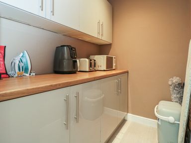 A laundry room with appliances on a countertop at Willow Cottage in Whiteparish
