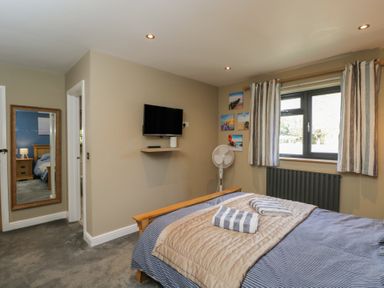A bedroom with a bed and television at Willow Cottage in Whiteparish