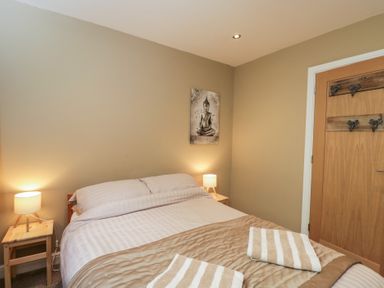 A bedroom with a bed and lamps at Willow Cottage in Whiteparish