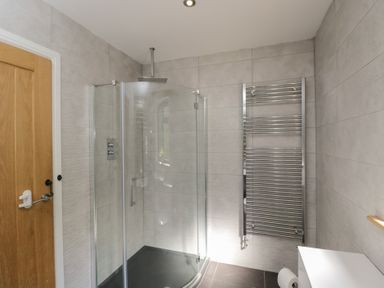 A bathroom with a shower and towel radiator at Willow Cottage Whiteparish