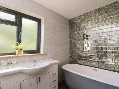 A bathroom with a bathtub and sink at Willow Cottage in Whiteparish